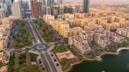 Téléchargez les photos : Des gratte-ciels dans le quartier de Barsha Heights et des immeubles de faible hauteur dans le quartier des Verts. Dubai skyline pendant toute la journée avec des ombres se déplaçant rapidement. Palmiers et arbres autour des rues - en image libre de droit
