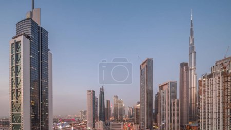 Téléchargez les photos : Vue aérienne de Dubai Downtown skyline avec de nombreuses tours les plus hautes de jour à la nuit transition timelapse. Zone d'affaires dans la ville urbaine intelligente. gratte-ciel et gratte-ciel d'en haut après le coucher du soleil, Émirats arabes unis. - en image libre de droit