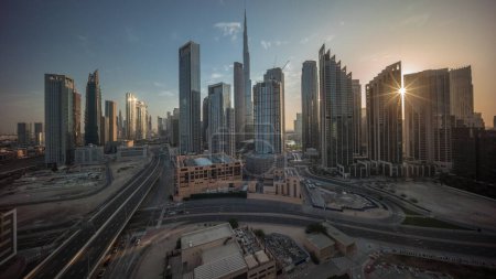 Téléchargez les photos : Vue aérienne de Dubai Downtown skyline pendant le lever du soleil avec de nombreuses tours timelapse. Rayons de soleil entre les gratte-ciel et les immeubles de grande hauteur d'en haut, EAU. Zone d'affaires dans la ville urbaine intelligente. - en image libre de droit