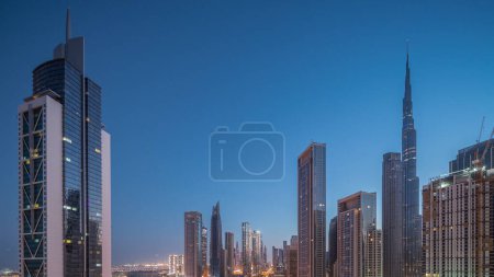 Téléchargez les photos : Vue aérienne du lever du soleil sur Dubai Downtown skyline avec de nombreuses tours de nuit au jour transition timelapse. Zone d'affaires dans la ville urbaine intelligente. gratte-ciel et gratte-ciel d'en haut tôt le matin, EAU. - en image libre de droit