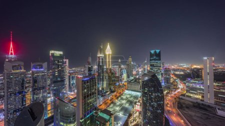 Téléchargez les photos : Vue panoramique Skyline des immeubles de grande hauteur sur Sheikh Zayed Road à Dubaï pendant toute la nuit timelapse, EAU. Des gratte-ciel éclairés de la place financière internationale d'en haut - en image libre de droit