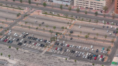 Foto de Gran estacionamiento cerca del centro comercial lleno de muchos coches timelapse vista aérea. Los vehículos entran y salen durante todo el día con sombras en movimiento - Imagen libre de derechos
