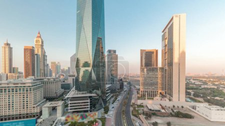Téléchargez les photos : Dubai International Financial district timelapse aérienne pendant toute la journée. Vue panoramique des tours de bureaux d'affaires et financiers. Gratte-ciel avec hôtels près du centre-ville et ombres se déplaçant rapidement - en image libre de droit