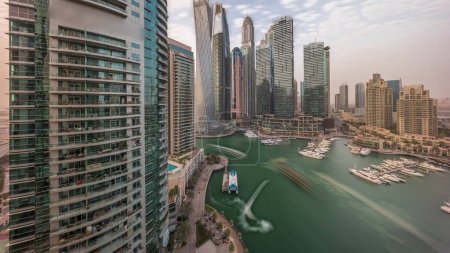 Téléchargez les photos : Dubai marina plus grands gratte-ciel et yachts dans le port aérien pendant toute la journée avec des ombres se déplaçant rapidement. Vue sur les immeubles d'appartements, les hôtels et les immeubles de bureaux, développement résidentiel moderne des EAU - en image libre de droit