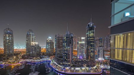 Foto de Panorama mostrando Dubai marina rascacielos más altos y yates en el puerto de la noche aérea timelapse. Vista en edificios de apartamentos, hoteles y bloques de oficinas, desarrollo residencial moderno de los EAU - Imagen libre de derechos