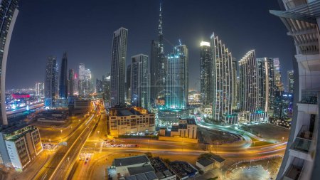 Photo for Aerial panorama of Dubai Downtown skyline with many illuminated towers around night timelapse. Business area in smart urban city. Skyscraper and high-rise buildings from above, UAE. - Royalty Free Image