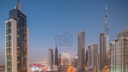 Téléchargez les photos : Vue aérienne de Dubai Downtown skyline avec de nombreuses tours les plus hautes de jour à la nuit transition timelapse. Zone d'affaires dans la ville urbaine intelligente. gratte-ciel et gratte-ciel d'en haut après le coucher du soleil, Émirats arabes unis. - en image libre de droit