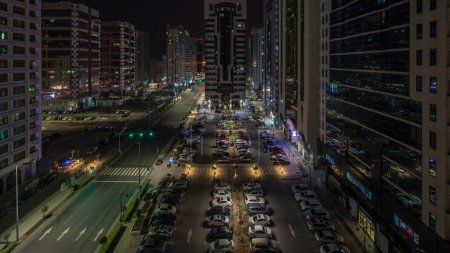 Foto de Edificios residenciales y arquitectura moderna de la ciudad de Abu Dhabi timelapse aéreo durante toda la noche, Emiratos Árabes Unidos. Vista desde arriba a los coches en el estacionamiento y torres con rascacielos en Emiratos Árabes Unidos - Imagen libre de derechos