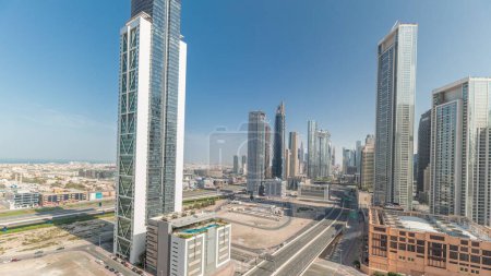 Foto de Panorama que muestra la vista aérea del centro de Dubái y el horizonte de la bahía de negocios con muchas torres timelapse. Área de negocios en la ciudad urbana inteligente. Rascacielos y edificios de gran altura desde arriba, Emiratos Árabes Unidos. - Imagen libre de derechos