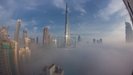Photo for Aerial view of Dubai city early morning during fog night to day transition timelapse. Futuristic city skyline with skyscrapers and towers during sunrise from above - Royalty Free Image