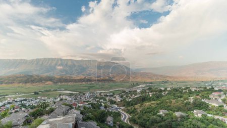 Photo for Panorama showing Gjirokastra city from the viewpoint of the fortress of the Ottoman castle of Gjirokaster timelapse. Albania aerial view to valley and mountains during sunset time - Royalty Free Image