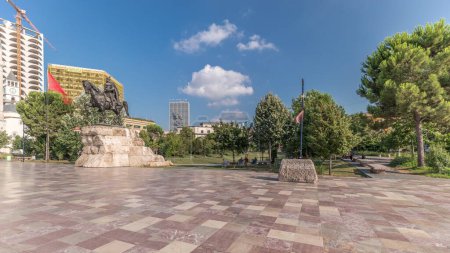 Téléchargez les photos : Panorama montrant le mémorial de Skanderbeg et la mosquée Ethem Bey avec théâtre sur la place principale de Tirana timelapse, Albanie. Arbres verts dans un parc et gratte-ciel autour - en image libre de droit