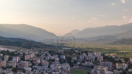 Photo for Gjirokastra city from the viewpoint of the fortress of the Ottoman castle of Gjirokaster timelapse. Albania aerial view during sunset with moving shadows over typical houses - Royalty Free Image