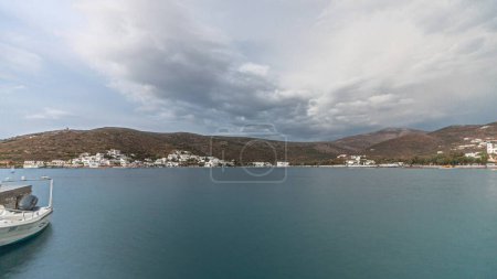 Photo for Panorama showing Amorgos island timelapse at evening during sunset. Traditional Greece - white houses on hills and ship in sea port in harbor, Cyclades - Royalty Free Image