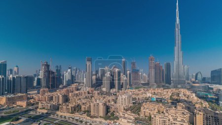 Téléchargez les photos : Dubaï Panorama du centre-ville le matin avec le soleil reflété par le plus haut gratte-ciel et d'autres tours vue du haut pendant le lever du soleil avec de longues ombres, Émirats arabes unis. Maisons traditionnelles de la vieille ville - en image libre de droit