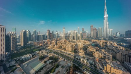 Téléchargez les photos : Dubaï Centre-ville avec le soleil reflété par le plus haut gratte-ciel et d'autres tours avec une vue ombragée depuis le sommet pendant le lever du soleil, Émirats arabes unis. Maisons traditionnelles de la vieille ville - en image libre de droit