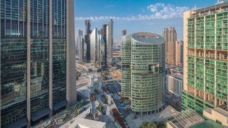 Foto de Dubai centro financiero internacional rascacielos aéreos noche al día timelapse transición. Torres iluminadas y zona de paseo en una avenida de puerta vista panorámica desde arriba antes del amanecer - Imagen libre de derechos