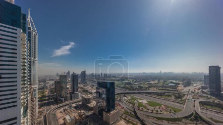 Photo for Sunrise over media city and al barsha heights district aerial panoramic timelapse from Dubai marina. Towers and skyscrapers with golf course and traffic on a highway intersection from above - Royalty Free Image