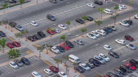Photo for Top view busy parking lot with many cars moving in and out timelapse. Aerial view from above with some taxi near shopping mall - Royalty Free Image