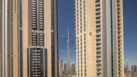 Téléchargez les photos : Les plus hauts gratte-ciel du centre-ville de Dubai situé sur la rue boulevard près du centre commercial aérien nuit à la transition de jour timelapse. Soleil réfléchi par la surface du verre au lever du soleil - en image libre de droit