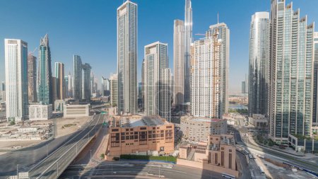 Téléchargez les photos : Vue aérienne de Dubai Downtown skyline avec des ombres mouvantes de nombreuses tours timelapse. Zone d'affaires dans la ville urbaine intelligente. gratte-ciel et immeubles de grande hauteur d'en haut, EAU. Trafic sur la route - en image libre de droit