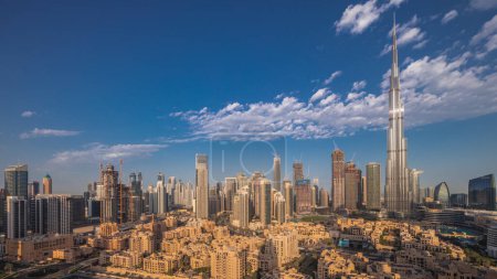 Foto de Dubai Downtown con reflexiones sobre el rascacielos más alto y otras torres vistas desde la cima durante el amanecer, Emiratos Árabes Unidos. Casas tradicionales del casco antiguo y nubes rosadas - Imagen libre de derechos