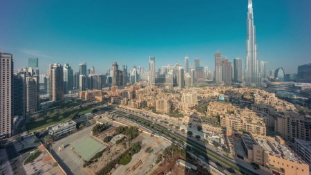 Téléchargez les photos : Dubaï Centre-ville avec le soleil reflété par le plus haut gratte-ciel et d'autres tours avec une vue ombragée depuis le sommet pendant le lever du soleil, Émirats arabes unis. Maisons traditionnelles de la vieille ville - en image libre de droit