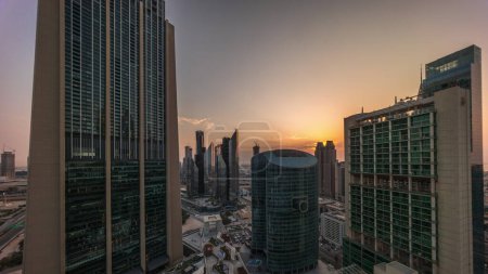 Foto de Rascacielos del centro financiero internacional de Dubái con paseo marítimo en un timelapse aéreo de la avenida de la puerta durante todo el día desde el amanecer hasta el atardecer. Las sombras se mueven rápido - Imagen libre de derechos