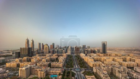 Téléchargez les photos : Panorama des gratte-ciel du quartier de Barsha Heights et des immeubles de faible hauteur du quartier des Verts timelapse aérien toute la journée à partir du lever du soleil. Dubai skyline avec des ombres se déplaçant rapidement - en image libre de droit