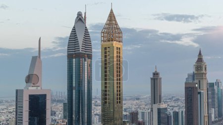 Photo for Skyline view of the high-rise buildings on Sheikh Zayed Road in Dubai aerial night to day transition timelapse, UAE. Skyscrapers in International Financial Centre from above before sunrise - Royalty Free Image