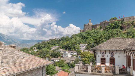 Foto de Panorama que muestra la ciudad de Gjirokastra desde el mirador con la fortaleza del castillo otomano de Gjirokaster timelapse. Albania vista aérea a casas históricas típicas con techos de piedra - Imagen libre de derechos