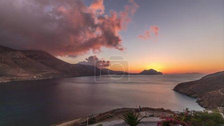 Téléchargez les photos : Panorama montrant des nuages orange au coucher du soleil sur l'île d'Amorgos timelapse aérien d'en haut. Grèce traditionnelle - maisons blanches sur les collines et la mer turquoise, Cyclades - en image libre de droit