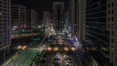 Photo for Residential buildings and modern city architecture of Abu Dhabi aerial timelapse during all night, UAE. View from above to cars on parking lot and towers with skyscrapers in United Arab Emirates - Royalty Free Image