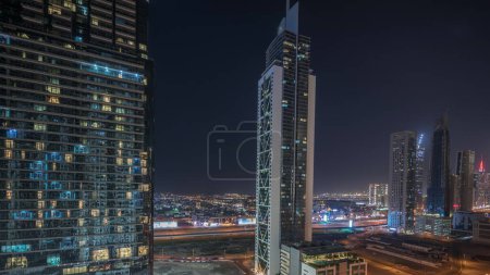 Photo for Panorama showing aerial view of Dubai Downtown and Business bay skyline with many illuminated towers night timelapse. Luxury area in smart urban city. Skyscrapers and high-rise buildings from above - Royalty Free Image