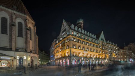 Photo for Kaufingerstrasse, shopping street and pedestrian zone in Munich downtown near the Marienplatz night timelapse. Panorama of historic buildings with people walking around. Bavaria, Germany - Royalty Free Image