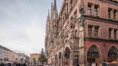 Photo for Main facade of the New Town Hall (Neues Rathaus) building at the northern part of Marienplatz timelapse hyperlapse in Munich. Fischbrunnen fountain in front. Cloudy sky. Bavaria, Germany. - Royalty Free Image