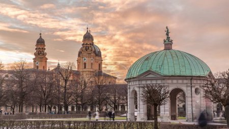 Téléchargez les photos : Le temple du pavillon Diana avec statue de Bavière au centre de la résidence Court Garden Garden à Munich timelapse pendant le coucher du soleil. Eglise baroque Theatinerkirche en arrière-plan. Allemagne - en image libre de droit