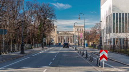 Photo for Propylaea or Propylaen timelapse with traffic on Brienner street. Monumental city gate in Konigsplatz (King's Square), Munich, Germany, Europe. The building in Doric order, entrance for Acropolis - Royalty Free Image