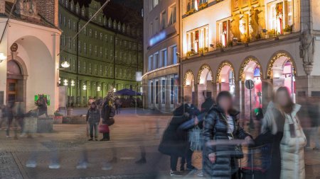 Téléchargez les photos : Kaufingerstrasse, rue commerçante et zone piétonne dans le centre-ville de Munich près de la Marienplatz nuit timelapse. Bâtiments historiques avec des gens se promenant. Entrée d'un musée. Bavière, Allemagne - en image libre de droit