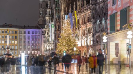 Photo for Marienplazt Old Town Square with New Town Hall night timelapse. Neues Rathaus and Town Hall Clock Tower Glockenspiel. Munich skyline, illuminated downtown cityscape during rain. Bavaria, Germany - Royalty Free Image
