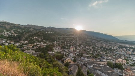 Téléchargez les photos : Panorama montrant la ville de Gjirokastra au coucher du soleil du point de vue de la forteresse du château ottoman de Gjirokaster timelapse. Albanie vue aérienne avec coucher de soleil - en image libre de droit