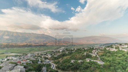 Panorama der Stadt Gjirokastra aus der Sicht der Festung der osmanischen Burg Gjirokaster im Zeitraffer. Albanien Luftaufnahme von Tal und Bergen bei Sonnenuntergang