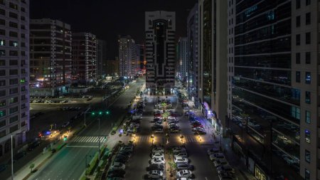 Téléchargez les photos : Bâtiments résidentiels et architecture moderne de la ville d'Abu Dhabi timelapse aérien pendant toute la nuit, EAU. Vue d'en haut pour les voitures sur le parking et les tours avec gratte-ciel aux Émirats Arabes Unis - en image libre de droit