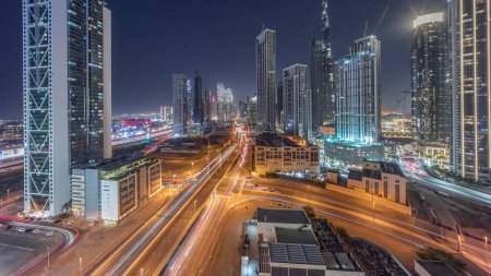 Téléchargez les photos : Vue panoramique aérienne du centre-ville de Dubaï avec de nombreuses tours intemporelles de transition de jour à nuit. Zone d'affaires dans la ville urbaine intelligente. gratte-ciel et gratte-ciel d'en haut après le coucher du soleil, Émirats arabes unis. - en image libre de droit