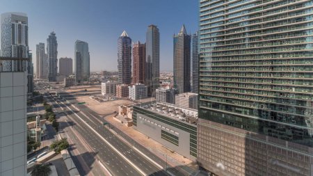 Téléchargez les photos : Business Bay skyline de quartier avec l'architecture moderne matin timelapse d'en haut. Panorama aérien des gratte-ciel et des tours de Dubaï près de l'autoroute principale au lever du soleil. Ombres longues se déplaçant rapidement - en image libre de droit