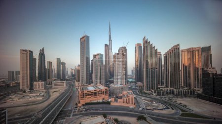Téléchargez les photos : Vue aérienne de Dubai Downtown skyline avec de nombreuses tours panorama timelapse pendant toute la journée. Zone d'affaires dans la ville urbaine intelligente. gratte-ciel et immeubles de grande hauteur avec ombres mobiles d'en haut, EAU. - en image libre de droit