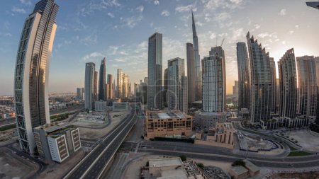 Foto de Panorama aéreo del horizonte del centro de Dubái con muchas torres de noche al día de transición timelapse. Área de negocios en la ciudad urbana inteligente. Rascacielos y edificios de gran altura desde arriba antes del amanecer, EAU. - Imagen libre de derechos