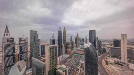 Foto de Vista panorámica del horizonte de los edificios de gran altura en Sheikh Zayed Road en Dubai timelapse aéreo durante todo el día desde el amanecer hasta el atardecer, Emiratos Árabes Unidos. Rascacielos en el Centro Financiero Internacional desde arriba - Imagen libre de derechos