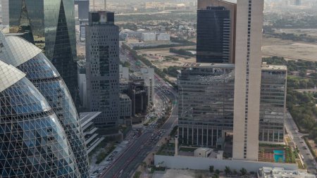Téléchargez les photos : Skyline view of the high-rise buildings around highway road in Dubai aerial timelapse during sunrise, UAE. Les gratte-ciel de la place financière internationale d'en haut tôt le matin - en image libre de droit