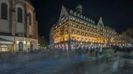 Téléchargez les photos : Kaufingerstrasse, rue commerçante et zone piétonne dans le centre-ville de Munich près de la Marienplatz nuit timelapse. Panorama des bâtiments historiques avec des gens qui se promènent. Bavière, Allemagne - en image libre de droit